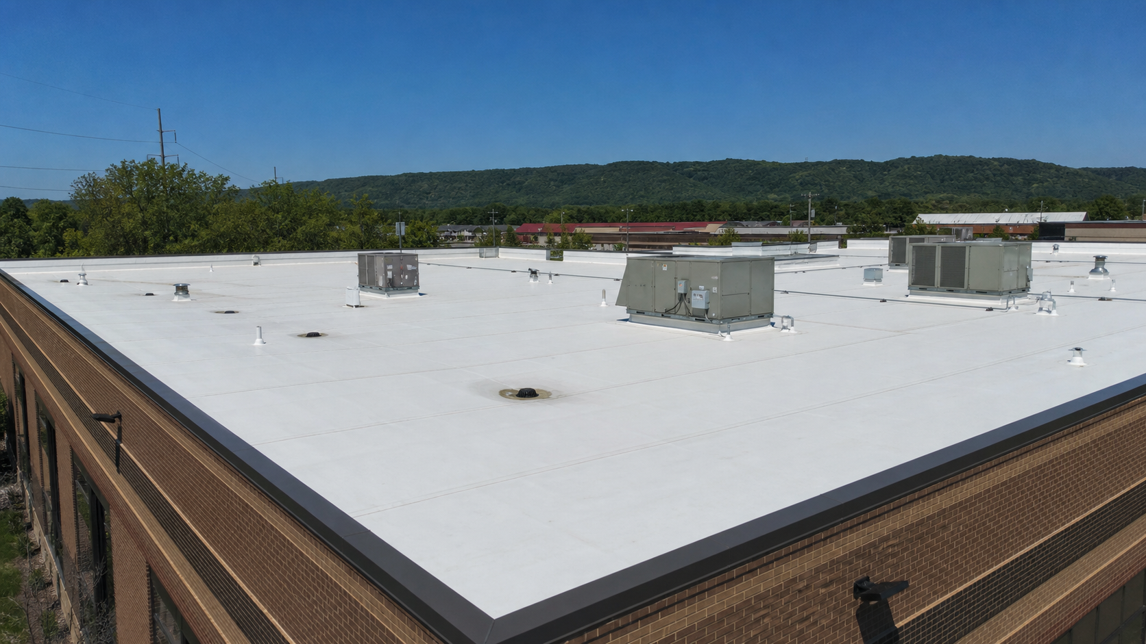 A commercial building with a white TPO flat roof system in North Alabama.